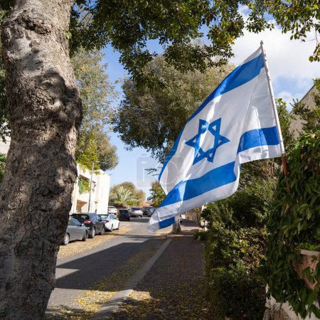 Eine israelische Flagge, die auf einer Straße in Israel gehisst wird, um Einigkeit und Unterstützung im Kampf gegen den islamischen Terror zu zeigen.