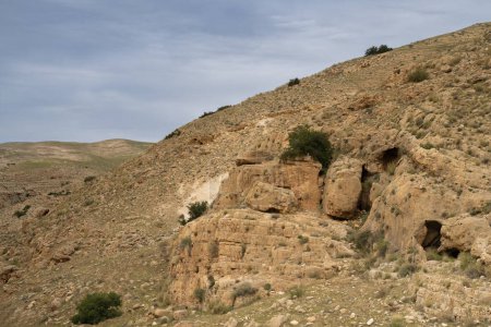 The Judea desert hills in Israel present a landscape of cliffs and caves, dotted with greenery following the winter season.