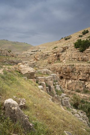 Photo for A landscape of cliffs and caves on the banks of the Prat stream in the Judea desert hills, Israel. - Royalty Free Image