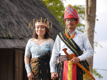 Foto de Novia y novio vestidos para el tradicional stand de bodas en frente de la casa de pueblo en Ruteng en la isla de Flores, East Nusa Tenggara, Indonesia - Imagen libre de derechos