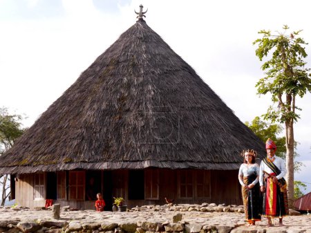 Téléchargez les photos : Mariée et marié habillés pour le traditionnel stand de mariage en face de la maison de village à Ruteng sur l'île de Flores, Nusa Est Tenggara, Indonésie - en image libre de droit