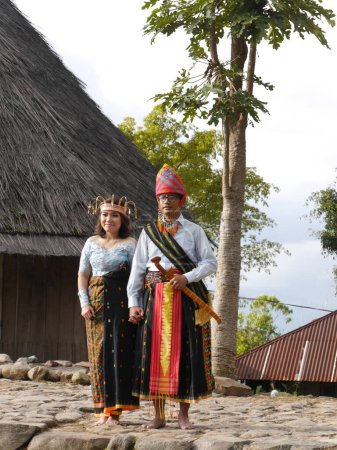 Téléchargez les photos : Mariée et marié habillés pour le traditionnel stand de mariage en face de la maison de village à Ruteng sur l'île de Flores, Nusa Est Tenggara, Indonésie - en image libre de droit