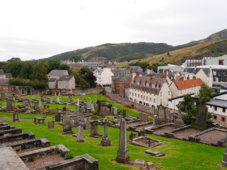 Téléchargez les photos : Pierres tombales dans un ancien cimetière avec vue sur les bâtiments d'Édimbourg, en Écosse. Photo de haute qualité - en image libre de droit