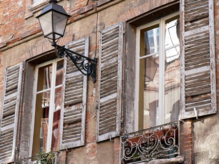 Attraktive Fassade mit Rollläden und Lampen, Toulouse, Frankreich. Hochwertiges Foto