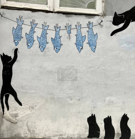 Schrullige schwarze Katze und Fisch auf einer Linie Street Art, Batumi, Georgien. Hochwertiges Foto