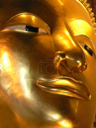 Imposing close up of the golden face of a Buddha statue, Myanmar. High quality photo