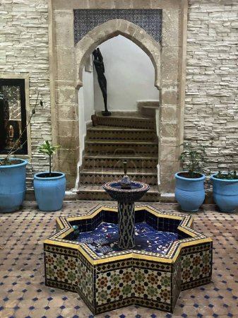 Riad patio con fuente de azulejos con dibujos y escaleras Essaouira, Marruecos. Foto de alta calidad