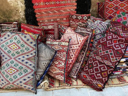  Nahaufnahme einer Auswahl farbenfroher, handgefertigter marokkanischer Kissen in traditionellen Mustern, die zum Verkauf stehen. Hochwertiges Foto
