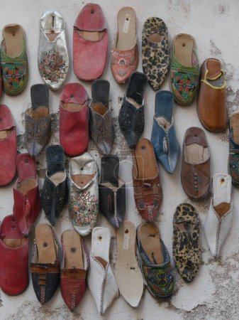 Téléchargez les photos : Présentoir coloré de pantoufles en cuir sur mur, Essaouira, Maroc. Photo de haute qualité - en image libre de droit