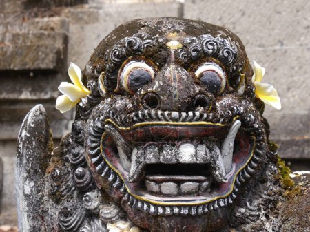 Großaufnahme des grotesken, beängstigenden Gesichts der Statue eines balinesischen Dämons mit starrenden Augen und Reißzähnen am Pura Sangara Meertempel in der Nähe von Sanur.