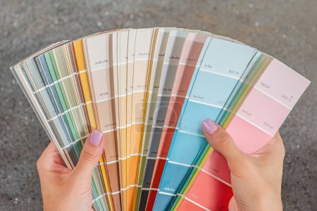 Photo for Color selection according to RAL. A woman designer chooses a shade from the RAL color palette. The concept of design work and color selection in the interior. High quality photo - Royalty Free Image