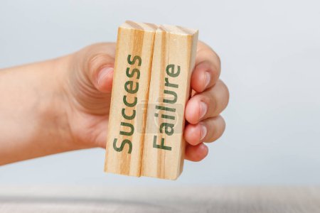 Photo for Success and failure. A hand holds two wooden cubes with the inscriptions SUCCESS and FAILURE For insertion into a design or project. High quality photo - Royalty Free Image