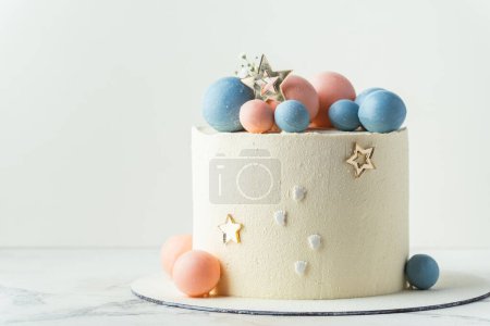 Photo for Baby shower party cake with white cream cheese frosting decorated with blue and pink chocolate spheres. Guess the gender of the upcoming child. He or She cake. Reveal the sex of the unborn baby. - Royalty Free Image