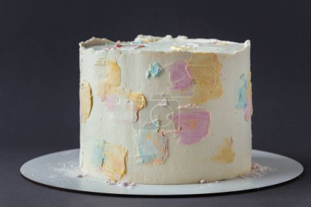 Photo for Cake with white cream cheese frosting decorated with multicolored smears on the dark grey background. Blank cake with a free space for text - Royalty Free Image