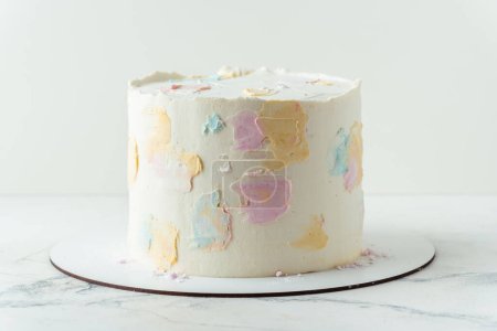 Photo for Cake with white cream cheese frosting decorated with multicolored smears on the white background. Blank cake with a free space for text - Royalty Free Image
