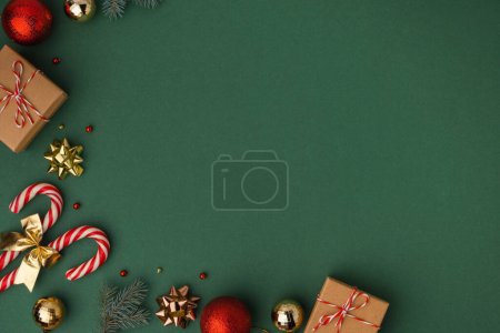 Foto de Fondo de Navidad con cajas de regalo de cartón, bastones de caramelo y juguetes de árbol de Navidad de oro. Sensación festiva de las próximas vacaciones. Fondo verde oscuro con espacio de copia para un texto de saludo. Puesta plana - Imagen libre de derechos
