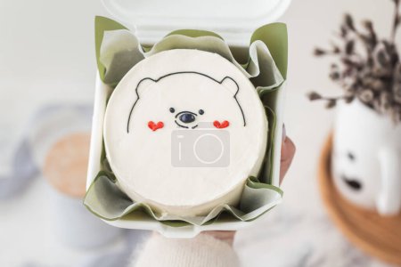 Small bento cake decorated with cute teddy bear silhouette and red hearts drawing. Cake as a gift for beloved one. Happy Valentine's cake