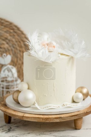 Photo for Christening cake with white cream cheese frosting decorated with mastic newborn baby sleeping on the edible angel wings. Little baby angel sleeping. Baby born celebration. - Royalty Free Image