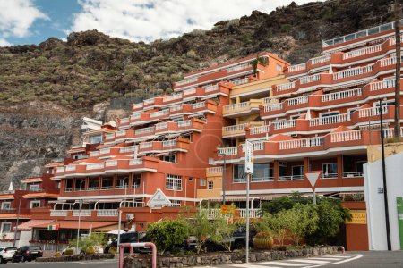 View from Puerto de Santiago on luxury apartments located in Los Gigantes rocks. Tenerife, Canary islands, Spain. Apartment building embedded into a cliff of the mountain