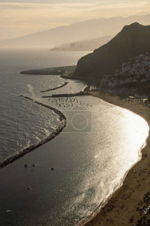 View from above of the sunset at Las Teresitas beach with yellow sand. Sun shine reflects in the sea during the sunset at beautiful beach near the Santa Cruz de Tenerife city, Canary Islands