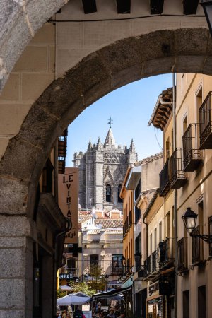 Photo for Avila, Spain - September 11, 2022: View of the old town with the tower of Cathedral on the background. View of the cathedral framed by an arch of the arcade of the Plaza del Mercado Chico or Small - Royalty Free Image