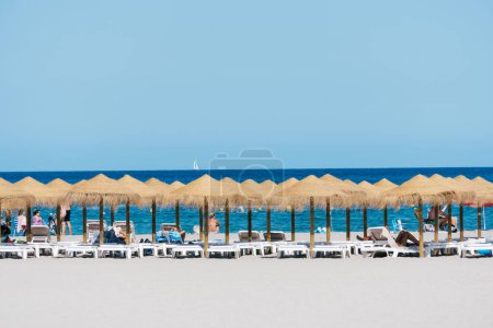 Téléchargez les photos : Javea, Espagne - 24 août 2022 : La plage d'El Arenal pendant l'été. Parapluies contre la mer et le ciel - en image libre de droit