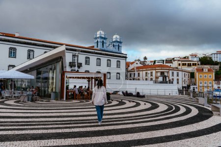 Foto de Angra do Heroismo, Portugal - 2 de julio de 2022: Acogedor restaurante en el puerto al atardecer. Isla Terceira, Azores. Gente disfrutando del tiempo libre - Imagen libre de derechos