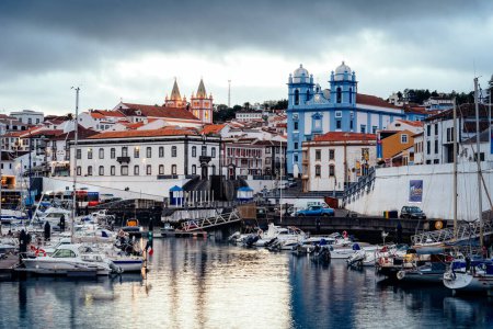 Foto de Angra do Heroismo, Portugal - 2 de julio de 2022: Vista del puerto y del casco antiguo al atardecer. Isla Terceira, Azores. - Imagen libre de derechos