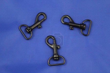 Photo for Three small black metal carabiners on blue fabric - Royalty Free Image