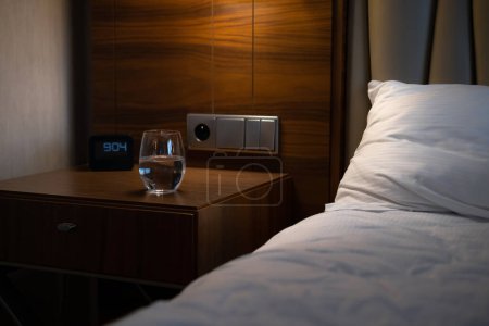 Téléchargez les photos : Cozy and inviting hotel room with a comfortable bed, clock and modern decor - perfect for a relaxing nights stay - en image libre de droit