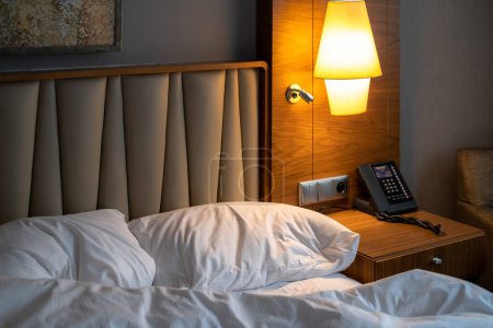 Téléchargez les photos : Cozy and inviting hotel room with a comfortable bed, clock and modern decor - perfect for a relaxing nights stay - en image libre de droit