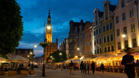 Photo for Scenic summer evening panorama of architectural pedestrians tourists people walk along the evening street of the Old Town GDANSK, POLAND - July 6, 2022 - Royalty Free Image
