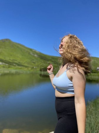 Téléchargez les photos : Une jeune fille aime voyager et conquérir les sommets des montagnes, elle est heureuse - en image libre de droit