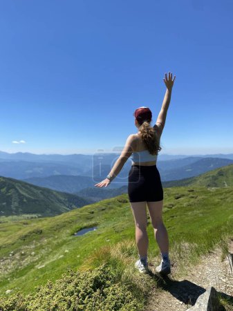 Téléchargez les photos : Une jeune fille aime voyager et conquérir les sommets des montagnes, elle est heureuse - en image libre de droit