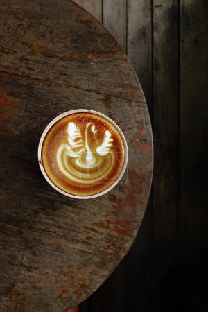 Photo for A cup of latte art coffee on wooden background - Royalty Free Image