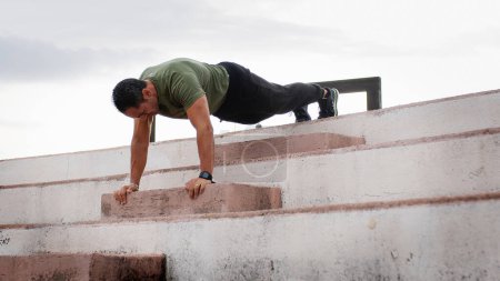 Photo for Man is making sport training gym outdoor during rainy and cloudy day. - Royalty Free Image