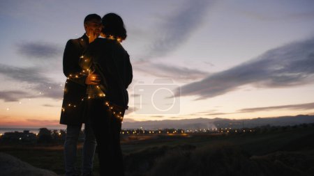 Lovely couple silhouette on the mountains against the sunset enjoy the valentines day together