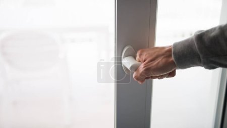 Photo for Hand closing a slider Ecology Window Of The House For High Hot. - Royalty Free Image