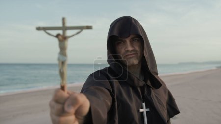 Photo for Monk With Statuette Of Jesus In His Hand Prays. - Royalty Free Image