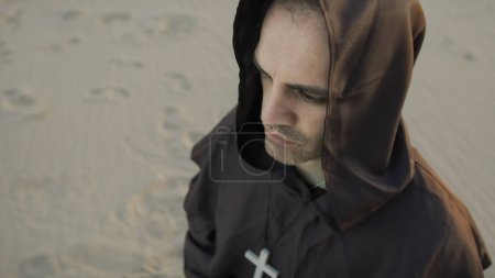 Téléchargez les photos : Moine religieux concentré dans la prière s'agenouillant sur la plage seul. - en image libre de droit