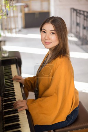 Téléchargez les photos : Portrait de jeune belle femme jouant du piano - en image libre de droit