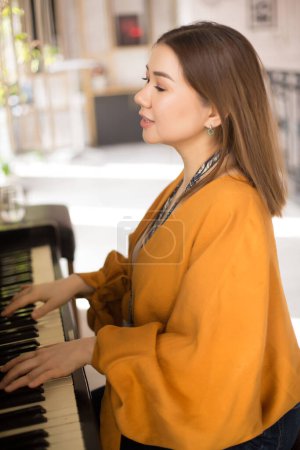 Téléchargez les photos : Portrait de jeune belle femme jouant du piano - en image libre de droit