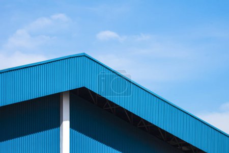 Photo for Blue corrugated steel roof with awning of warehouse building against blue sky background - Royalty Free Image