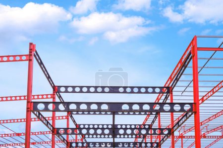 Red and black Castellated Beam metal of Industrial Building Structure in Construction Site against blue sky background