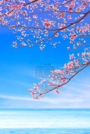 Téléchargez les photos : Fleurs de Tecoma rose fleurissant sur les branches sur flou coloré Vue sur la mer dans un cadre vertical, Beau fond naturel avec espace de copie - en image libre de droit