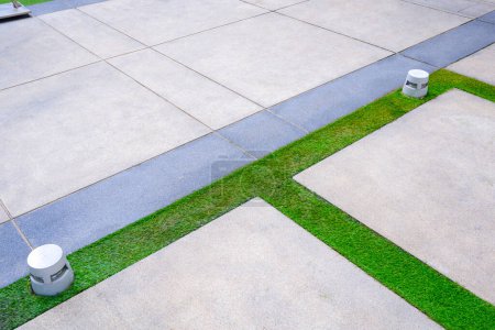 Foto de Dos linternas de tierra led en césped artificial y pavimento de piedra de grava en el área del patio delantero - Imagen libre de derechos