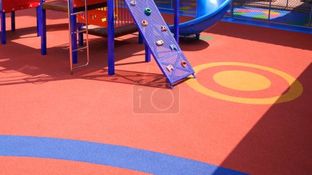 Foto de Colorido piso de goma con equipo de patio al aire libre en la escuela de jardín de infantes - Imagen libre de derechos