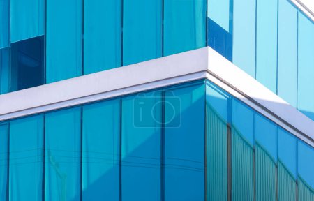 Photo for Sunlight and shadow on surface of modern glass office building with blue roller blinds inside of room, low angle and perspective side view - Royalty Free Image
