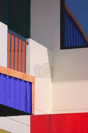 Abstract geometric colorful exterior architecture pattern of industrial office building wall background in street minimal style and vertical frame with sunlight and shadow on surface