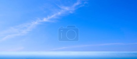 Fondo de horizonte panorámico de cielo azul y suave veta de nubes sobre el mar con reflejo de luz en la superficie del agua por la mañana, Idílica vista natural tranquila del paisaje marino con espacio para copiar
